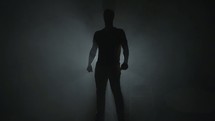 silhouette of a man standing in darkness