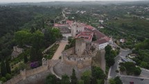 Drone view of the Convent of Christ in Tomar, Portugal with lush green surroundings