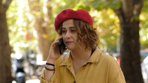 a woman in a hat talking on a cellphone 