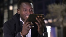 a man texting outdoors at night 