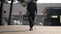 blind man walking with a guide stick 