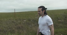 Young man walking on unpaved, dirt road on summer day explore, hiking, worshipping and praying. Lifestyle, worship and prayer concept.