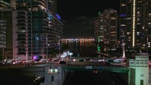 Forward Drone Shot Over Brickell Avenue and Miami River at Night With Traffic