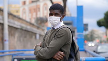 young man in a city wearing a face mask 