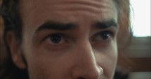 Closeup of the eyes of a sad, anxious, emotional man in church.