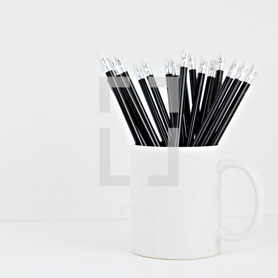 black pencils in a white mug