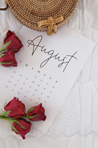 red roses on an August calendar 