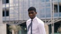 young man in a tie standing in a city 