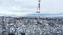 Transmit mast on a snowy city hill