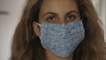 a young woman putting on a face mask 