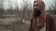 Jesus Christ dressed in brown robes and shroud in the wilderness temptation by the Devil for 40 days and 40 nights. Could also be used to depict a biblical prophet like Noah, Abraham, Elijah, Moses or John the baptist. 