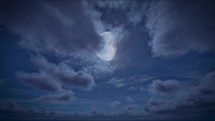 Timelapse of full moon night and starry blue sky with moving clouds. The moon on cloudy sky. Christmas night background. Beautiful cloudscape