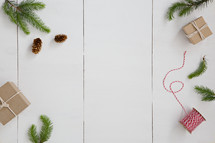 pine cones, thread, and gifts wrapped in brown paper on white background 