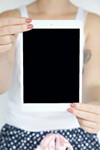 a woman holding up a blank tablet screen 