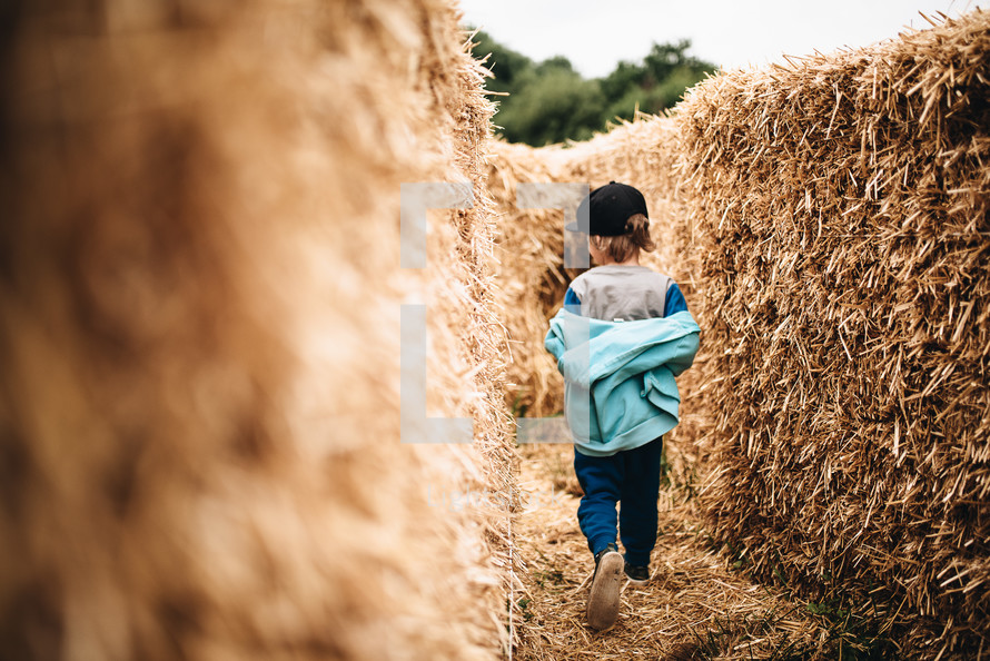 a child exploring a hay maze 