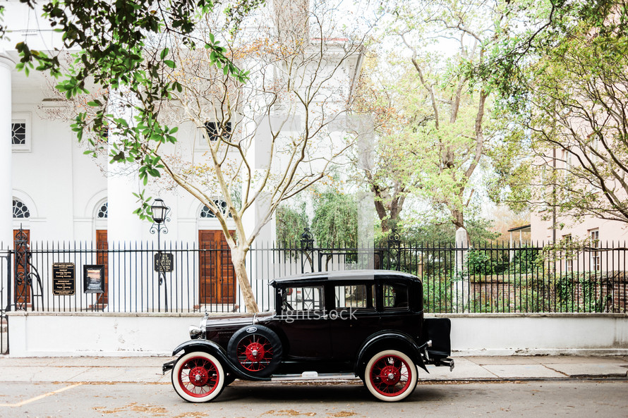 vintage car in front of an historic home 