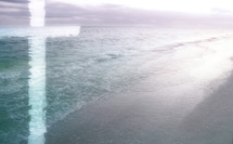 light cross superimposed on calm, soft-focus beach scene in turquoise green and purple 