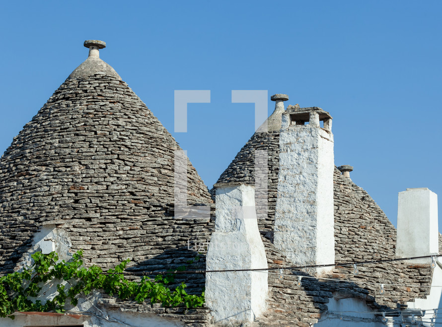 Traditional trulli houses with conical roofs made of stone in alberobello, a unesco world heritage site in puglia, italy, are shining in the sun