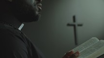 African American Pastor Preaching with Bible in Catholic Church