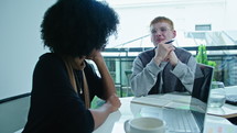 Gen Z Businessman Discussing Ideas with Black Female Coworker on Meeting
