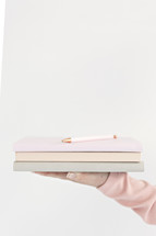 a woman holding a stack of journals 
