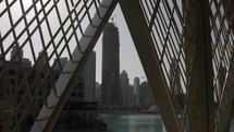 Distant skyscraper, buildings in Dubai under construction with cranes on the to near the Burj Khalifa.