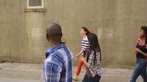 group of young adults walking in an alley 