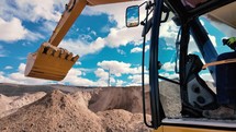 Excavator cab and shovel dumping dirt