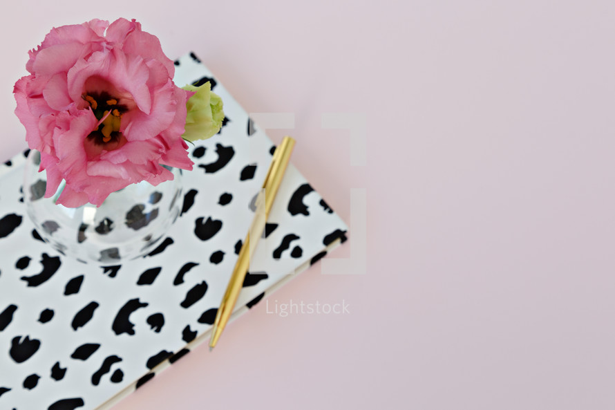 dalmatian spotted notebook, pen, and flowers in a vase 