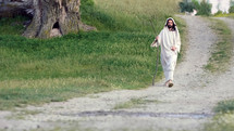 Jesus Christ walking on a country road at sunset.
