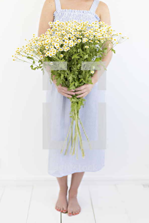 a woman holding a bouquet of white daisies 