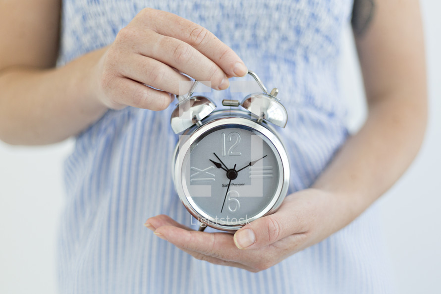 a woman holding an alarm clock 
