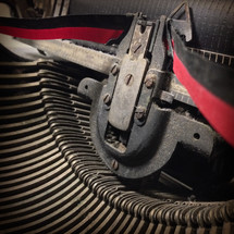 closeup of a vintage, dust-covered, manual typewriter with black and red ribbon