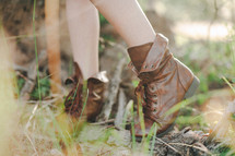 Boots on a young woman in grass.
