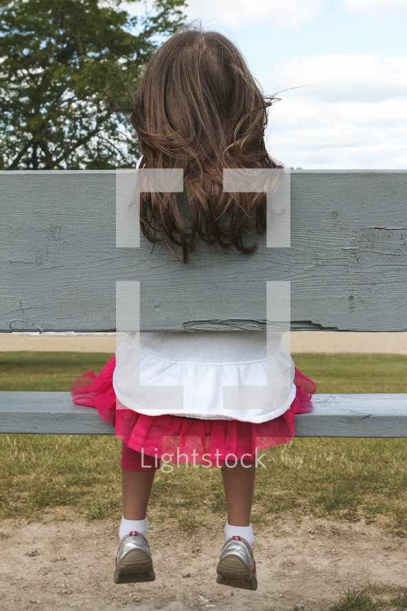 child sitting on a park bench 
