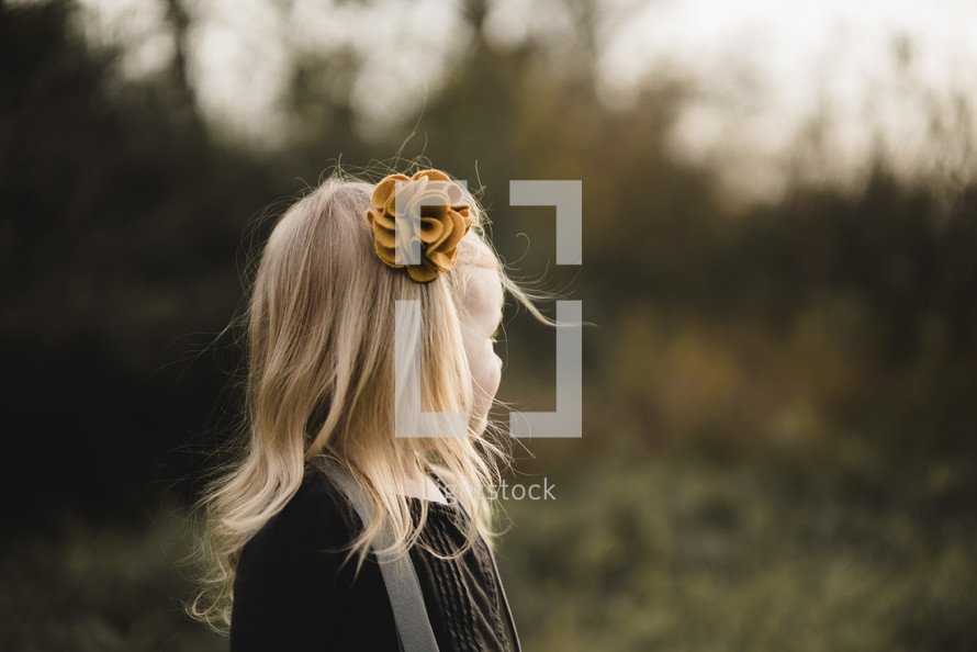 a blonde girl with a flower bow in her hair 