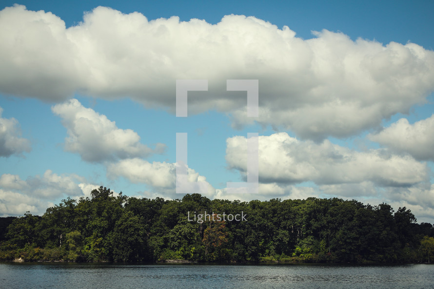clouds in a blue sky over a lake 