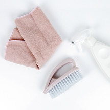 pink towel, brush, and spray bottle 