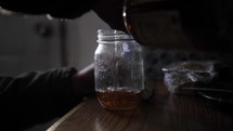 Alcoholic man pouring liquor into glass and drinking alcohol, liquor in cinematic slow motion.