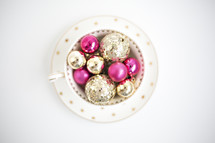gold and fuchsia ornaments in a bowl 