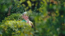 The statue of a Buddhist is sitting with his hands clasped, in front of the trees. Dolly shot