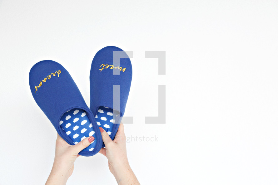 woman holding bedroom slippers 