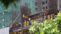 Asian Construction Workers Building Skyscraper