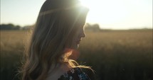 Sunlight shines on woman's hair in summer sunset in slow motion.