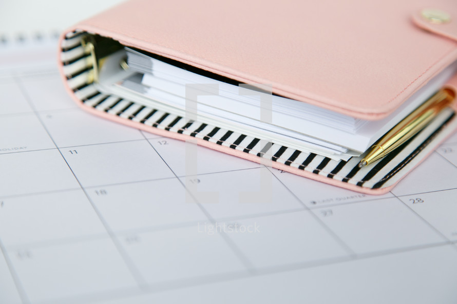 pen and planner on a calendar 