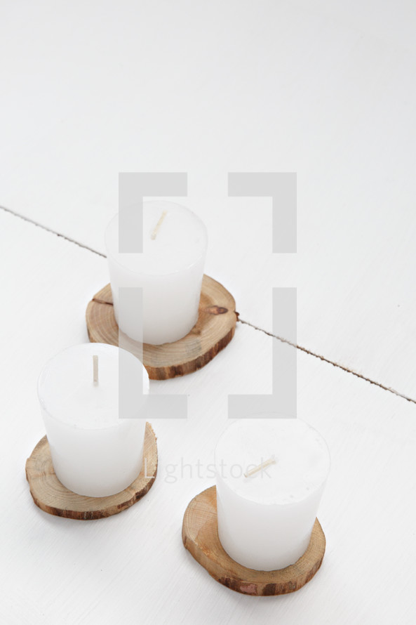 candles on wood slices on a white background 