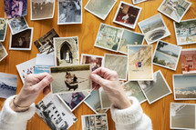 Top view of a senior woman looking through old photos  themes of memories nostalgia photos retired
