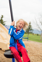 a child playing on a playground outdoors 