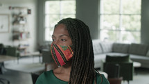 an African American professional woman in the office wearing a face mask 