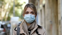 a woman wearing a face mask outdoors 